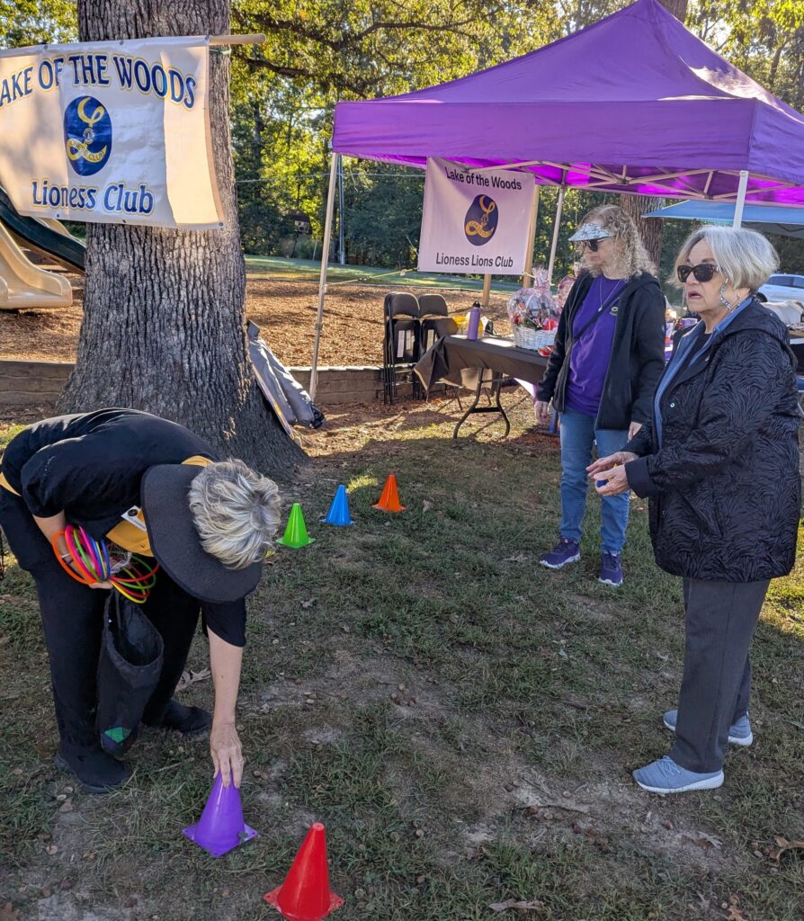 A woman adjusts colorful cones on the grass at a community event organized by the Lake of the Woods Lioness Club